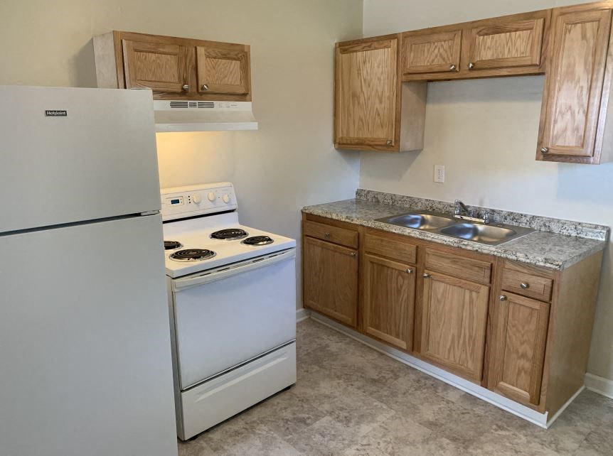 a kitchen with a stove refrigerator and sink