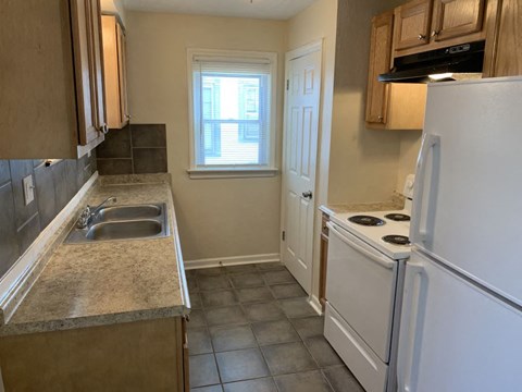 a kitchen with a stove refrigerator and sink