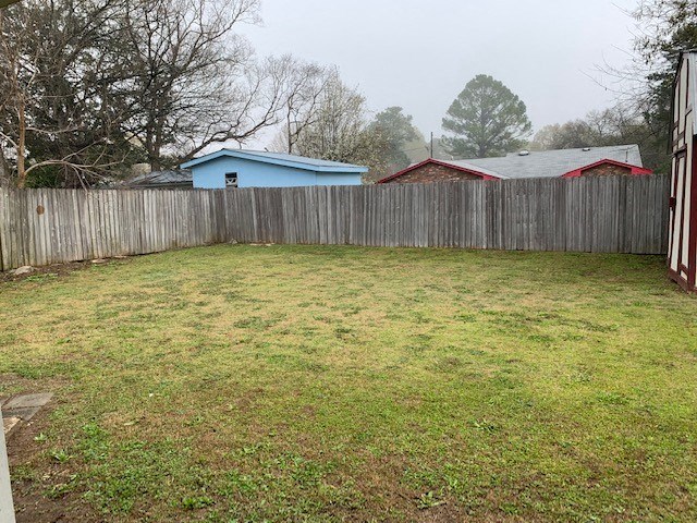 a backyard with a fence and a blue house