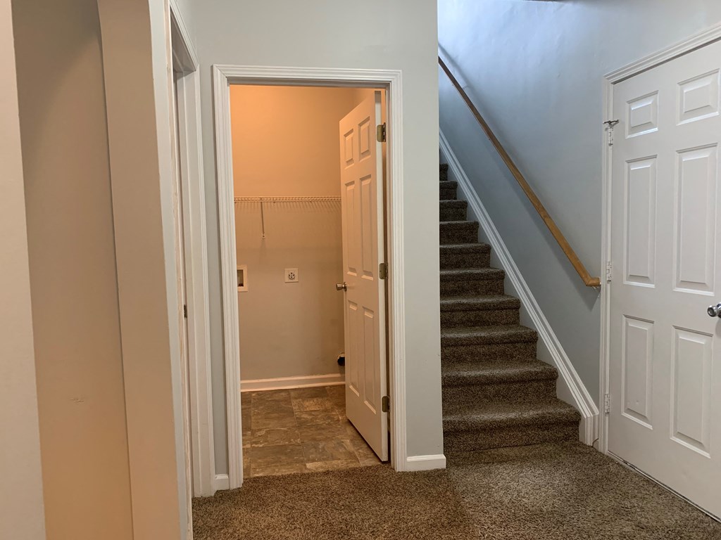 a stairwell in a home with stairs and a door open to a hallway and