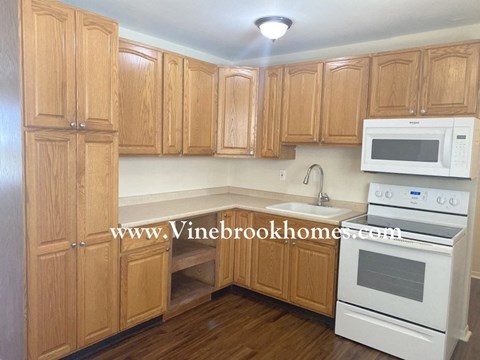 A kitchen with wooden cabinets and white appliances.