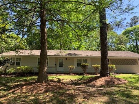 a white house with two trees in front of it