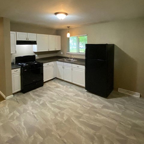 a kitchen with black appliances and white cabinets