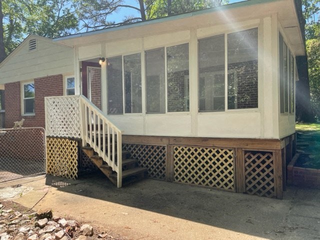 a house with a porch and a deck with a fence