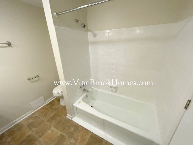 a white bathroom with a tub and a toilet