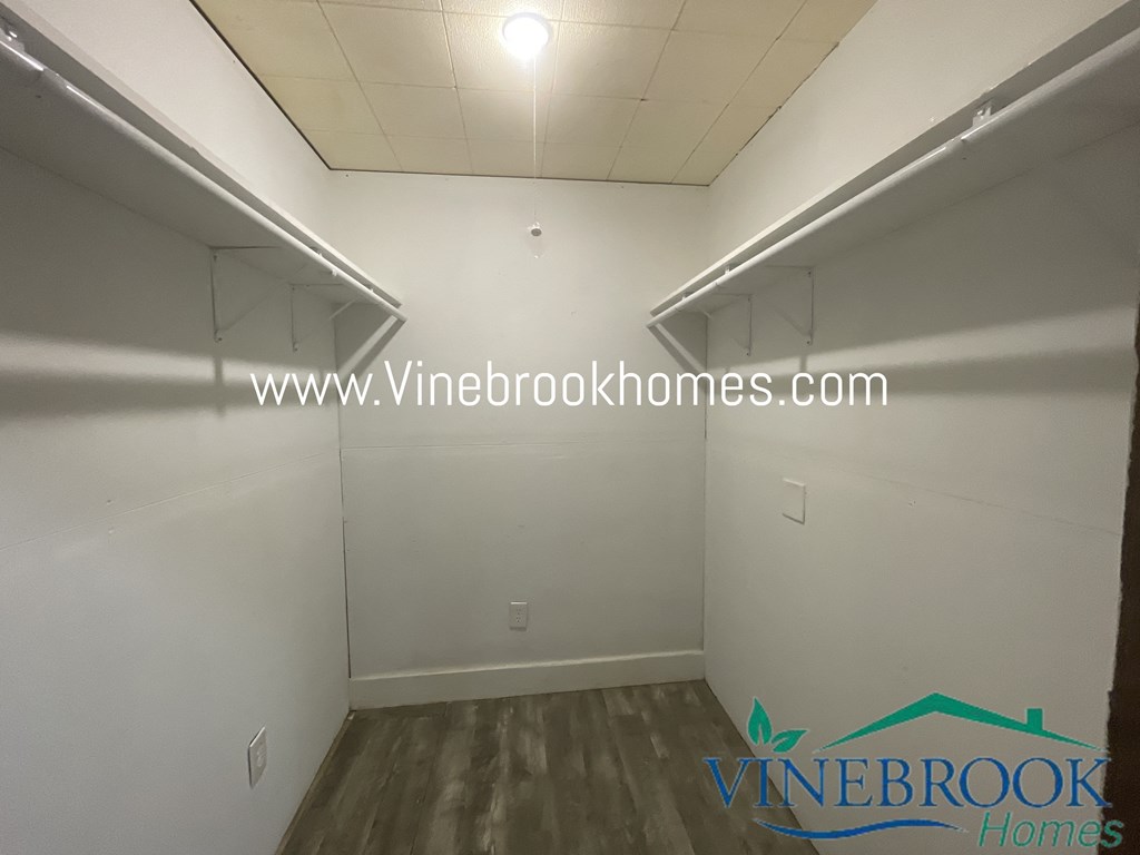 a small room with two shelves on the wall and a wooden floor