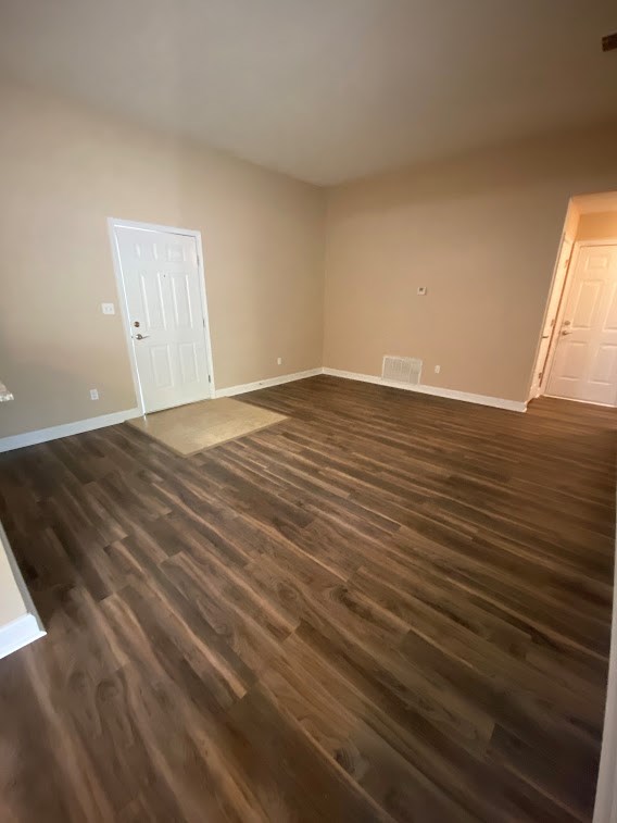 A room with wooden flooring and two white doors.