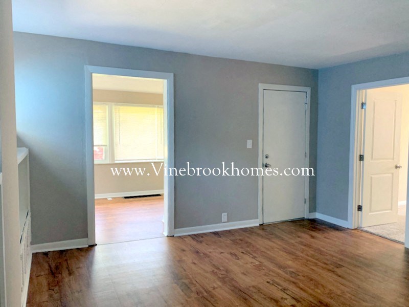 an empty living room with blue walls and a wood floor
