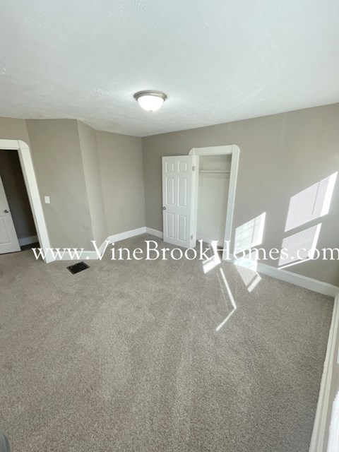A room with a carpeted floor and a white door.
