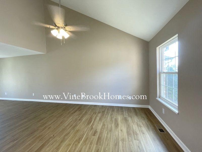 a living room with a ceiling fan and wood floors