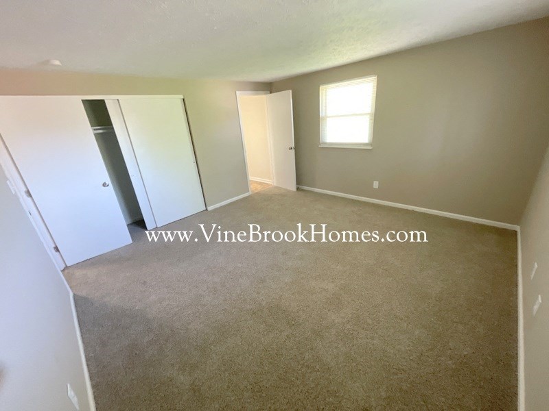 an empty living room with a closet and a window