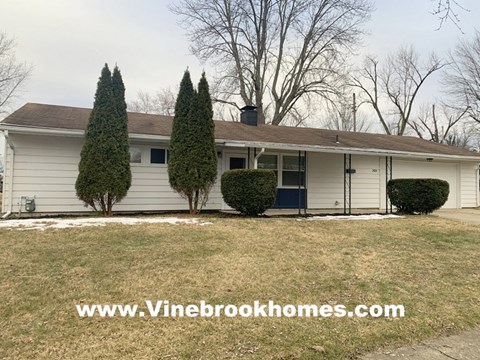 a white house with a yard and trees