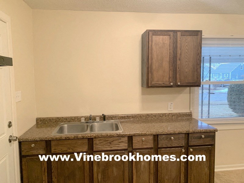 a kitchen with a sink and cabinets and a window