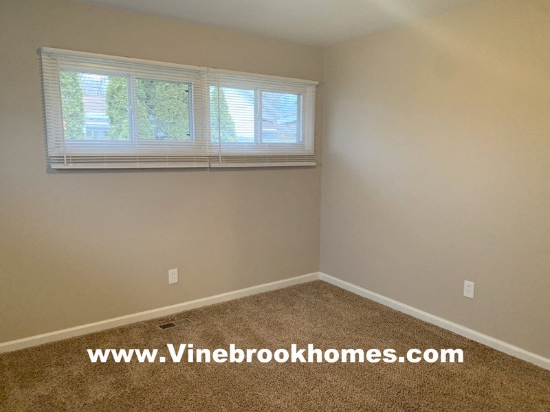 a empty room with a window and a carpet