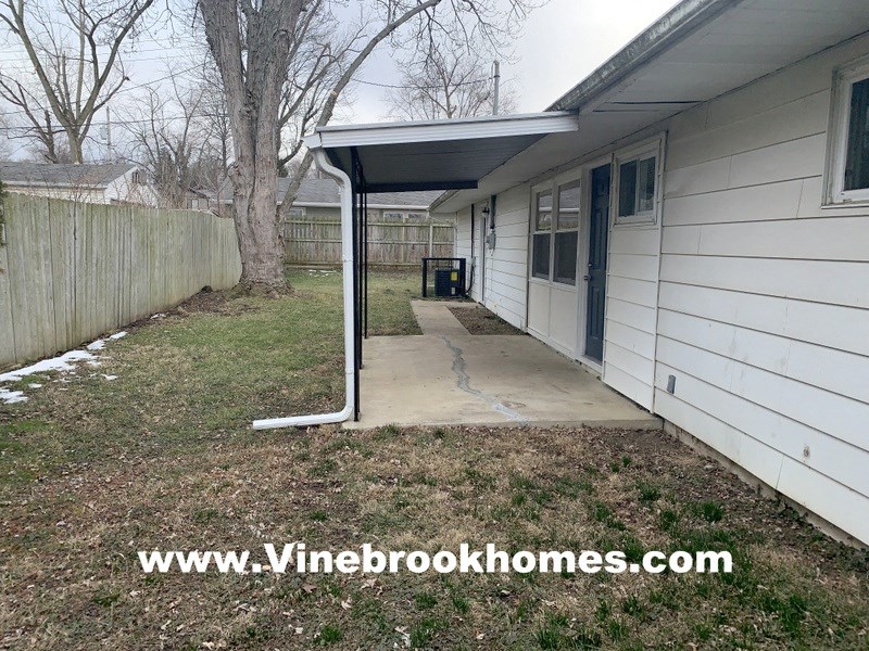 a covered patio in the backyard of a house
