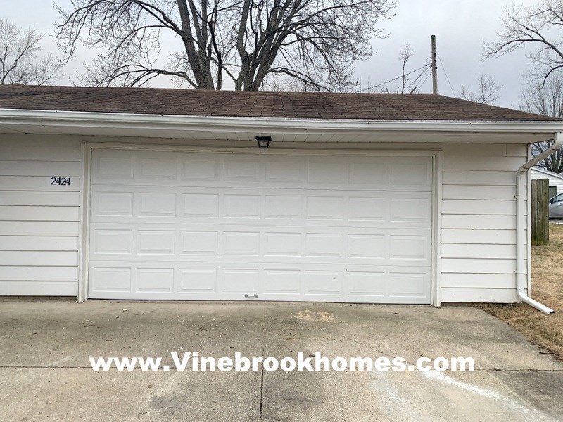a white garage with a white door and a driveway