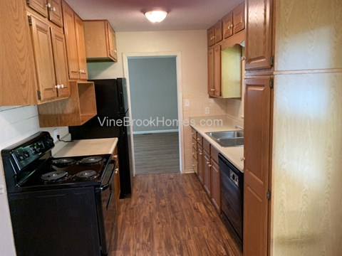 A kitchen with wooden cabinets and a black stove top oven.