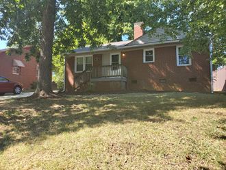 a house with a large yard and a tree in front of it