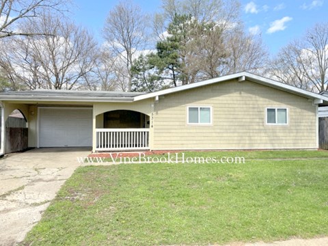 A two-car garage with a porch and a website address on the image.