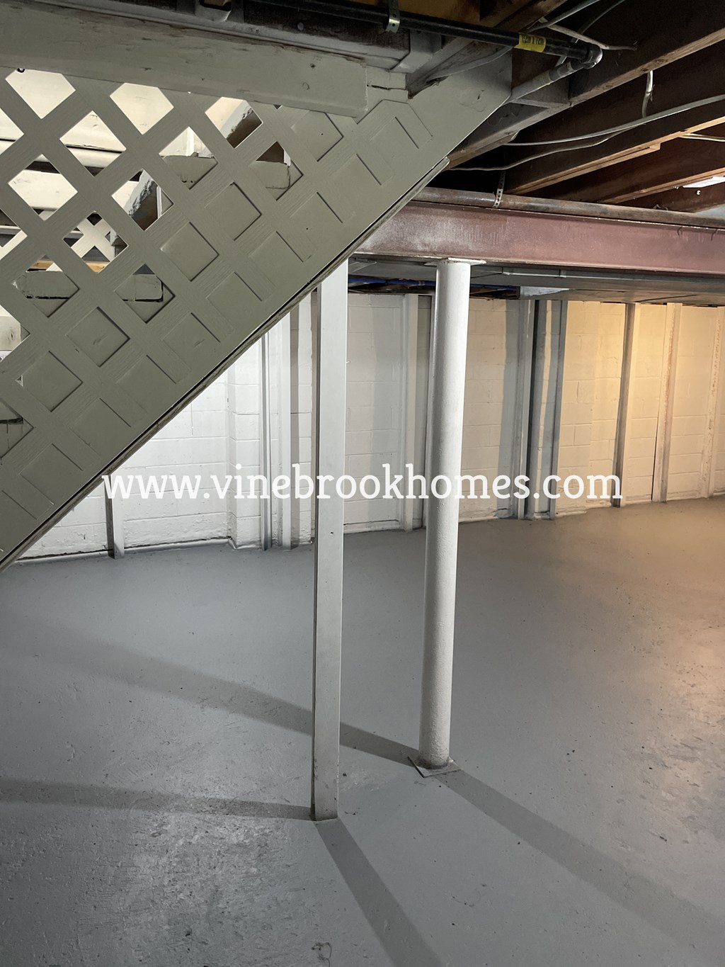 a steel support pillar in a basement under a staircase