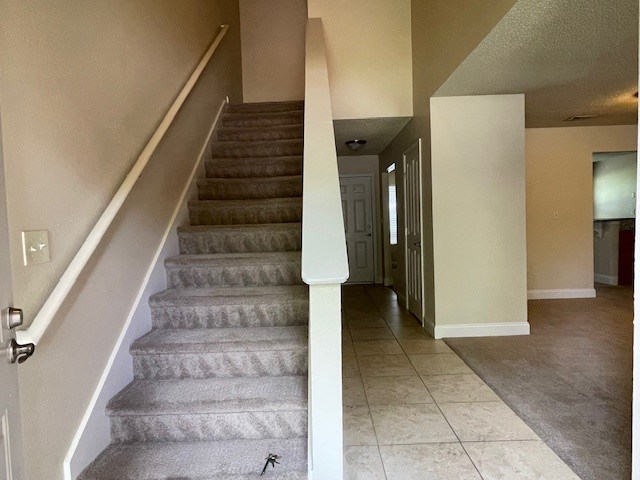 A staircase with a carpeted runner and a white railing.