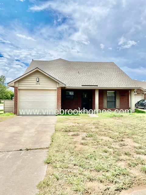 front view of a house with a driveway and a garage door