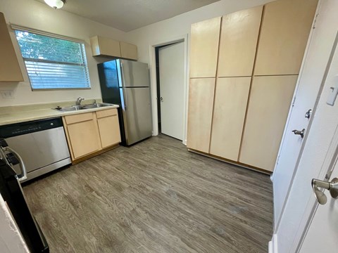 A kitchen with wooden cabinets and a refrigerator.
