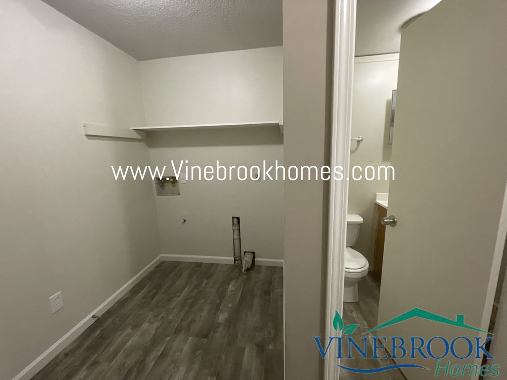 a small bathroom with a toilet and a white wall