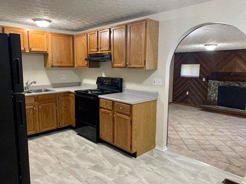 A kitchen with wooden cabinets and black appliances.
