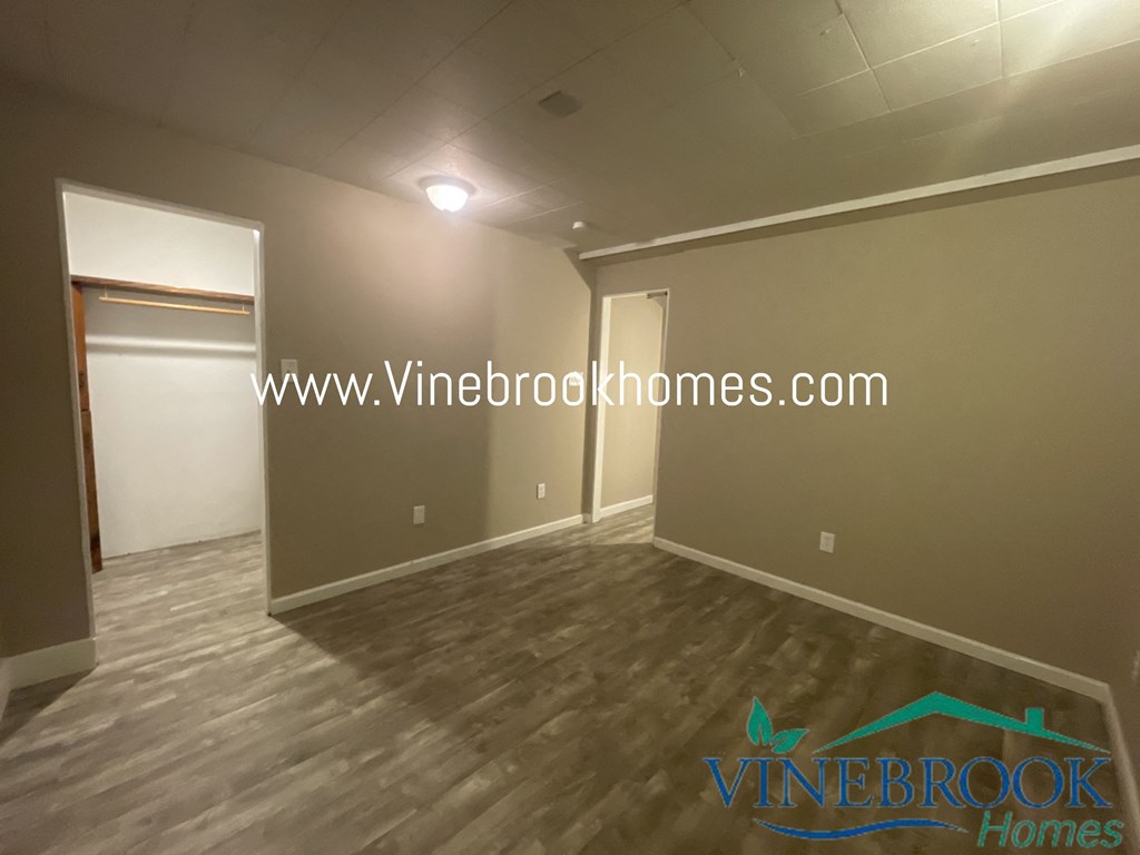 a living room with a hard wood floor and gray walls and a white door
