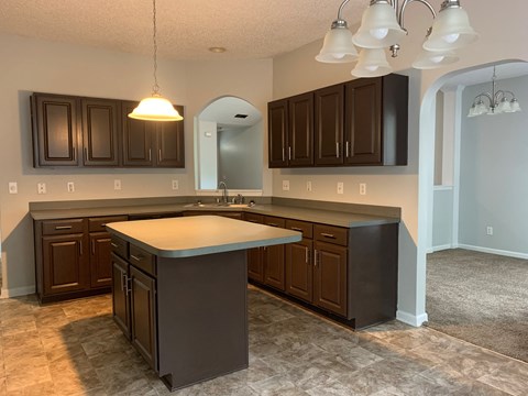 a kitchen with dark cabinets and a white counter top
