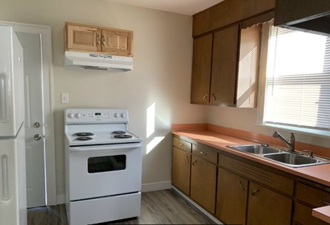 A white stove and oven in a kitchen with wooden cabinets.