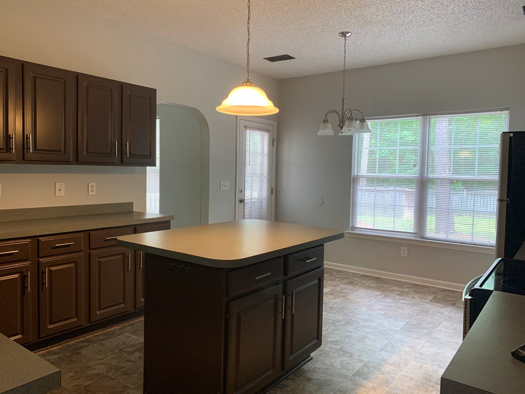 an empty kitchen with an island in the middle of it