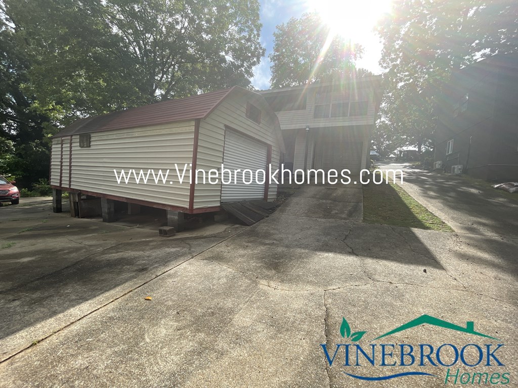 a house with a trailer parked in front of a driveway