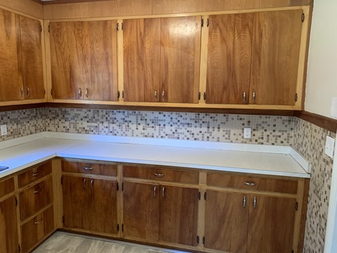 A kitchen with wooden cabinets and a tile backsplash.