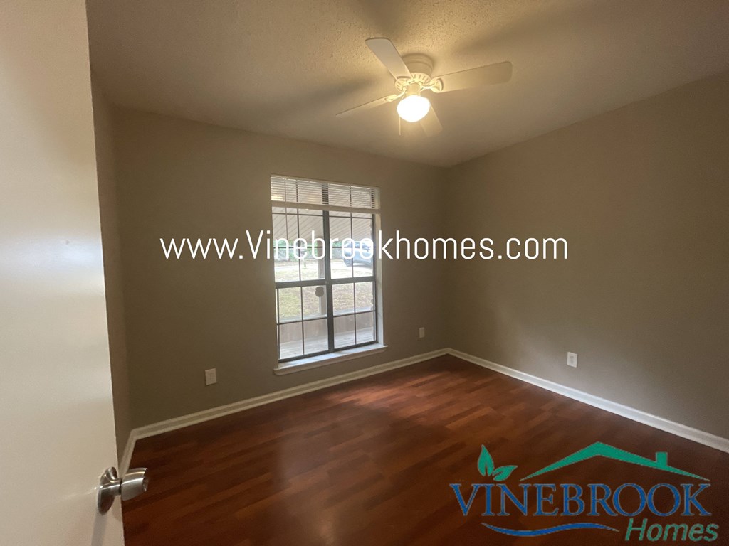 a living room with a ceiling fan and a window