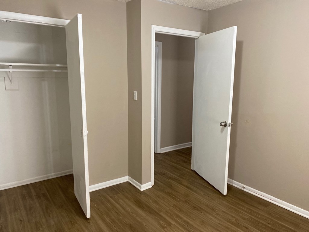 a bedroom with a closet and a door open