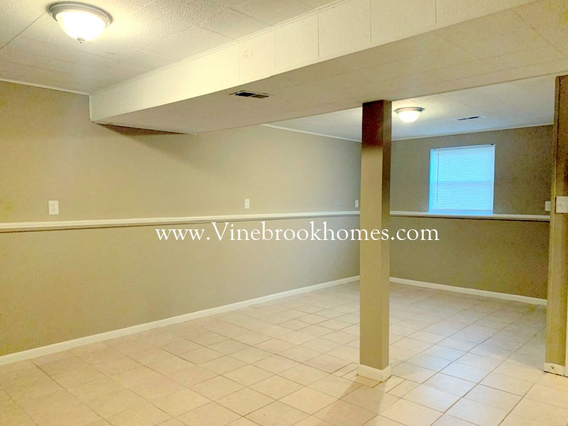 an empty living room with a white tile floor
