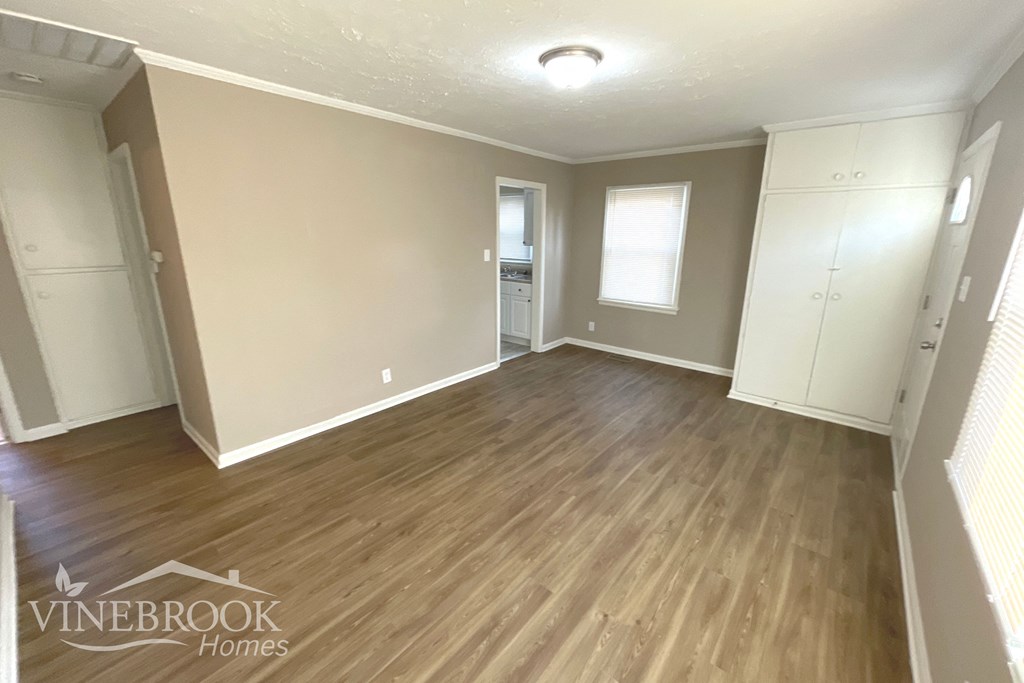 the living room of a renovated house with wood flooring