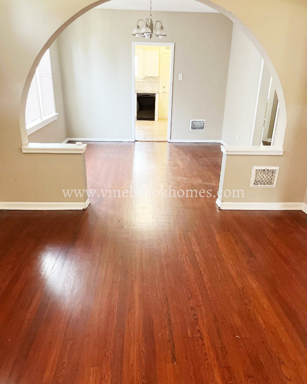 a view from the living room into the hallway and dining room of an empty house