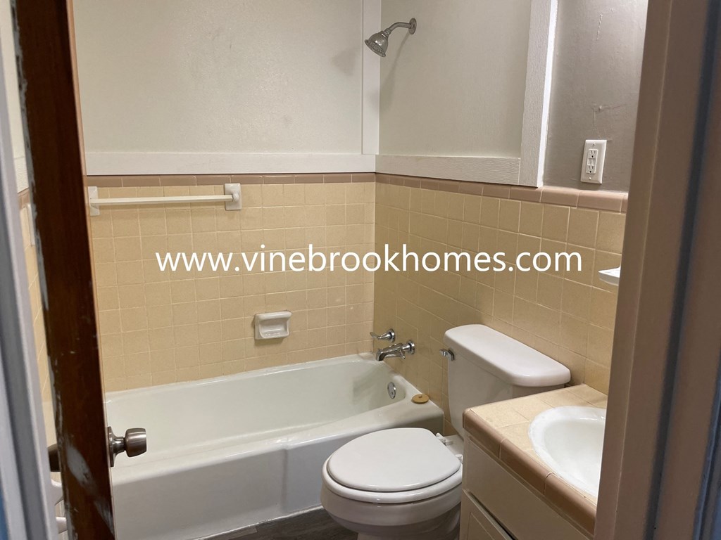 a bathroom with a toilet and a sink and a bath tub