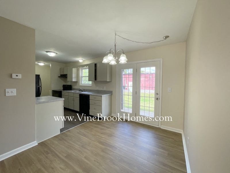 a kitchen and a living room with a wood floor