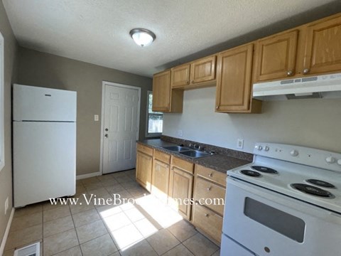 a kitchen with white appliances and wooden cabinets