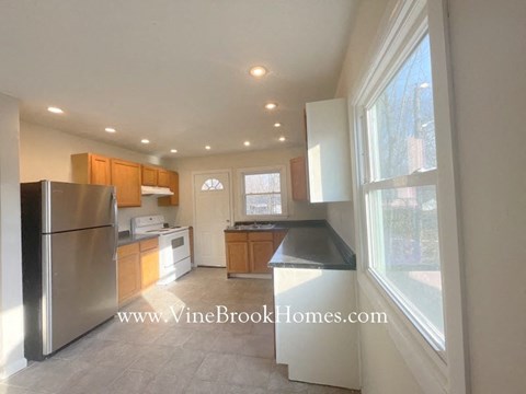 a kitchen with a stainless steel refrigerator and a large window