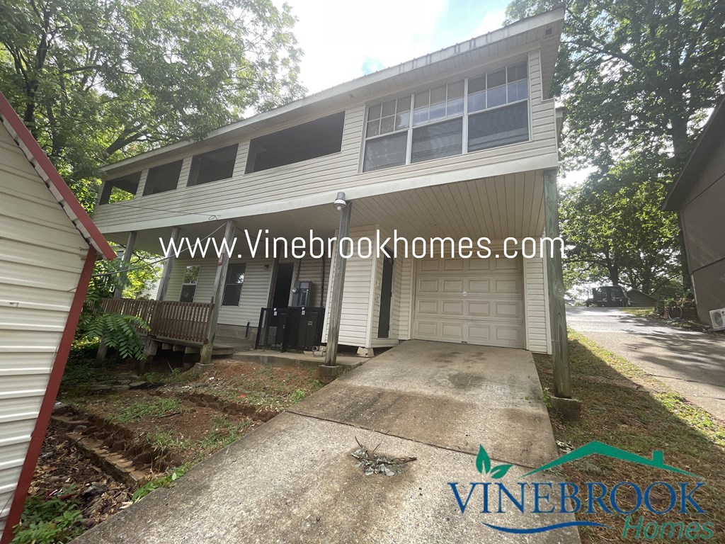 the front of a house with a driveway and a garage door
