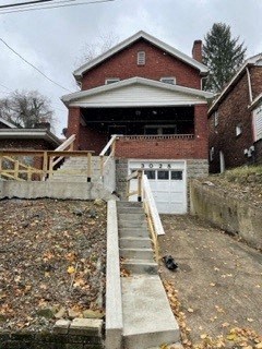 a house with stairs and a driveway in front of it