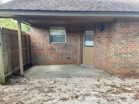 the back door of a brick house with a concrete driveway