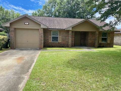 a brick house with a driveway and a garage door
