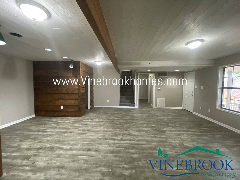 a large room with a carpeted floor and a wooden wall