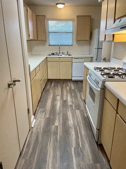 A kitchen with a white stove and wooden cabinets.